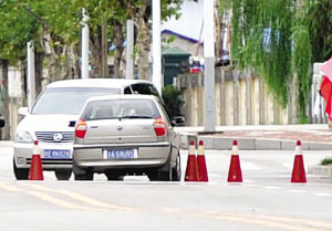 在世博中心门口，这辆轿车不顾阻拦，毫不减速地冲向隔离桩